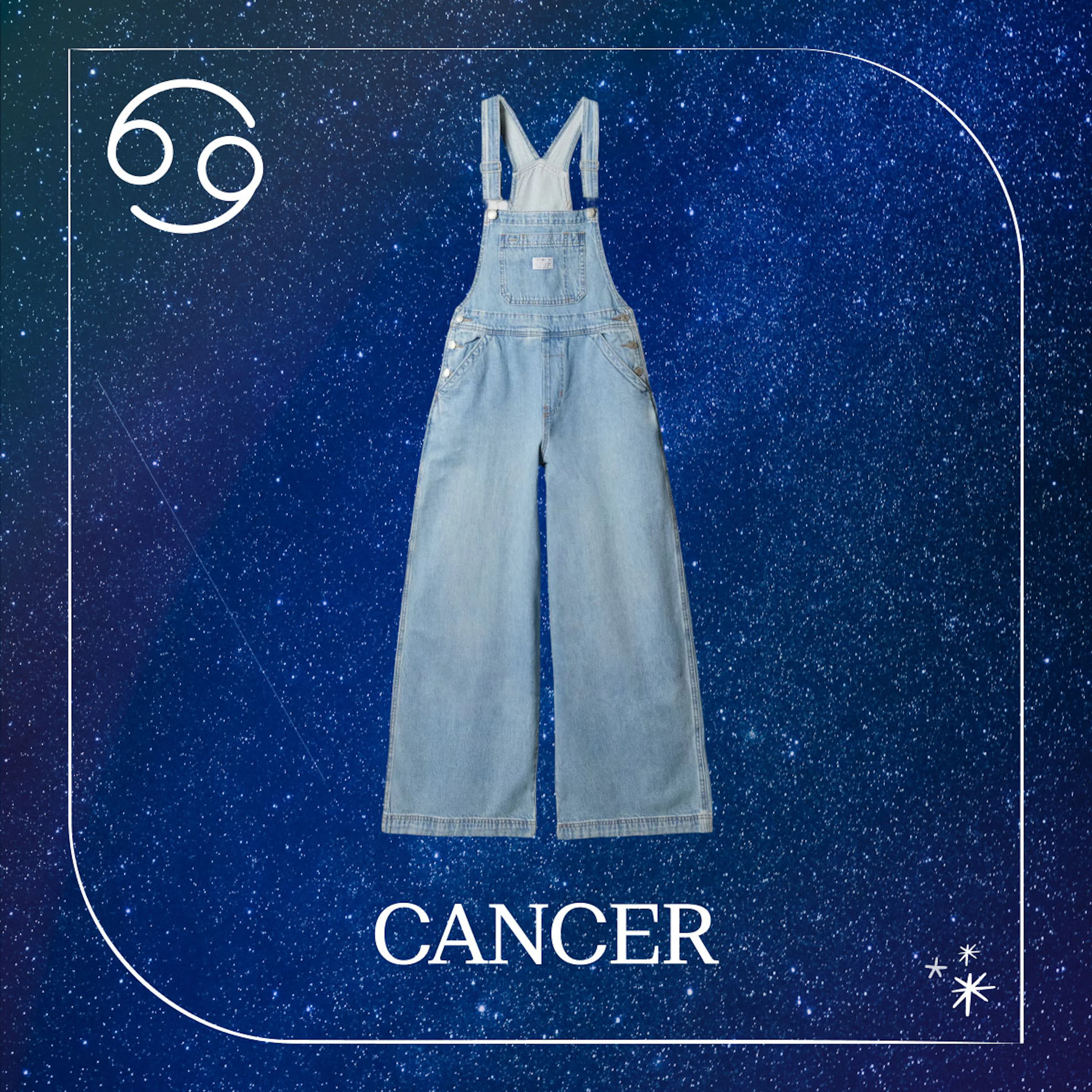 Lyseblå denim-overall med vide ben mot en stjernehimmel-bakgrunn. Stjernetegnet Kreps symbol og teksten CANCER vises.