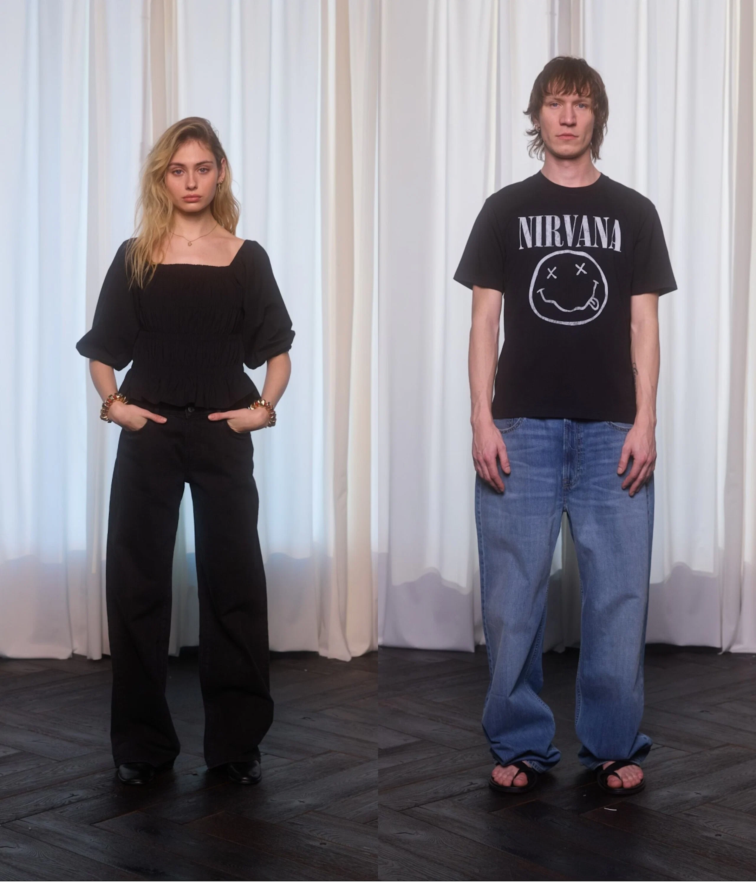 Nainen mustassa asussa ja mies Nirvana-t-paidassa ja farkuissa seisovat valkean verhon edessä.