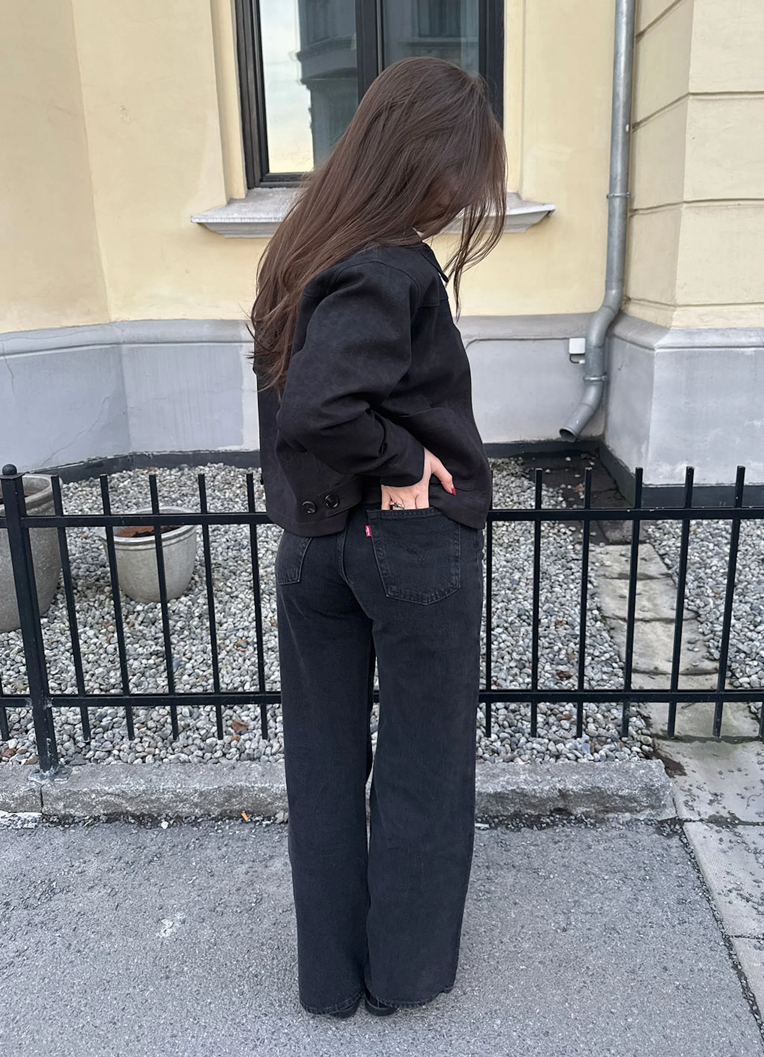 Mustat Levi's wide leg -farkut edestä ja takaa, päällä musta takki ja ruskea toppi, jalassa mustat kengät.