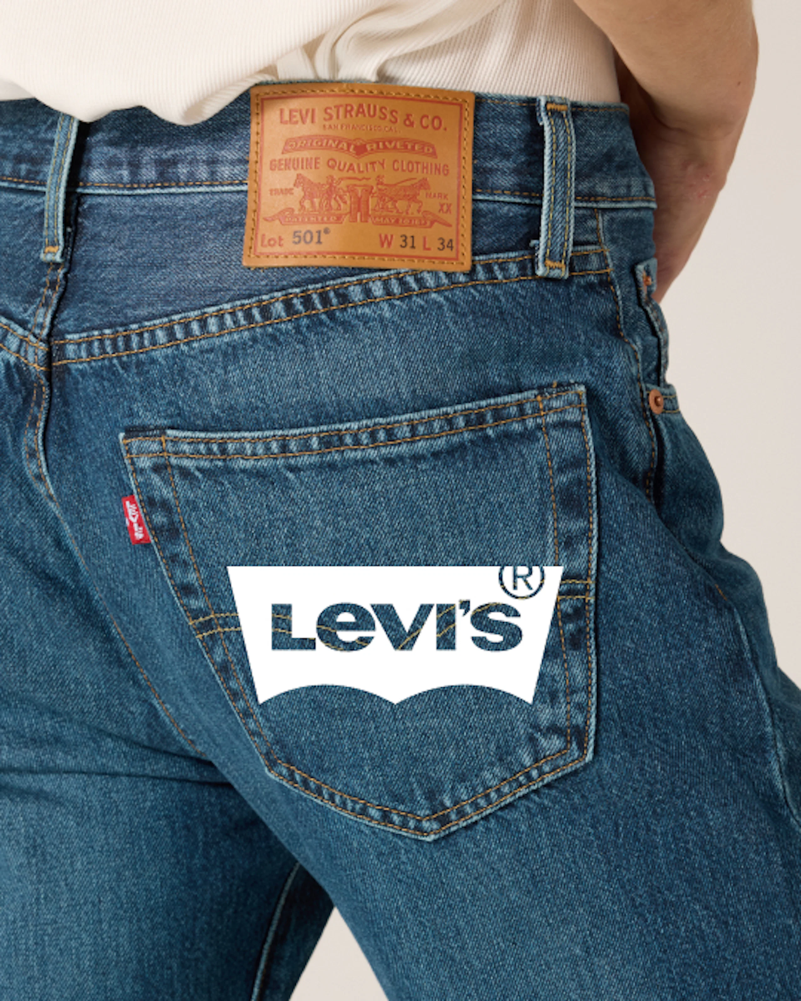 Nærbilde av baksiden av Levi's 501 mellomvasket blå jeans som viser lærmerket og baklommen.