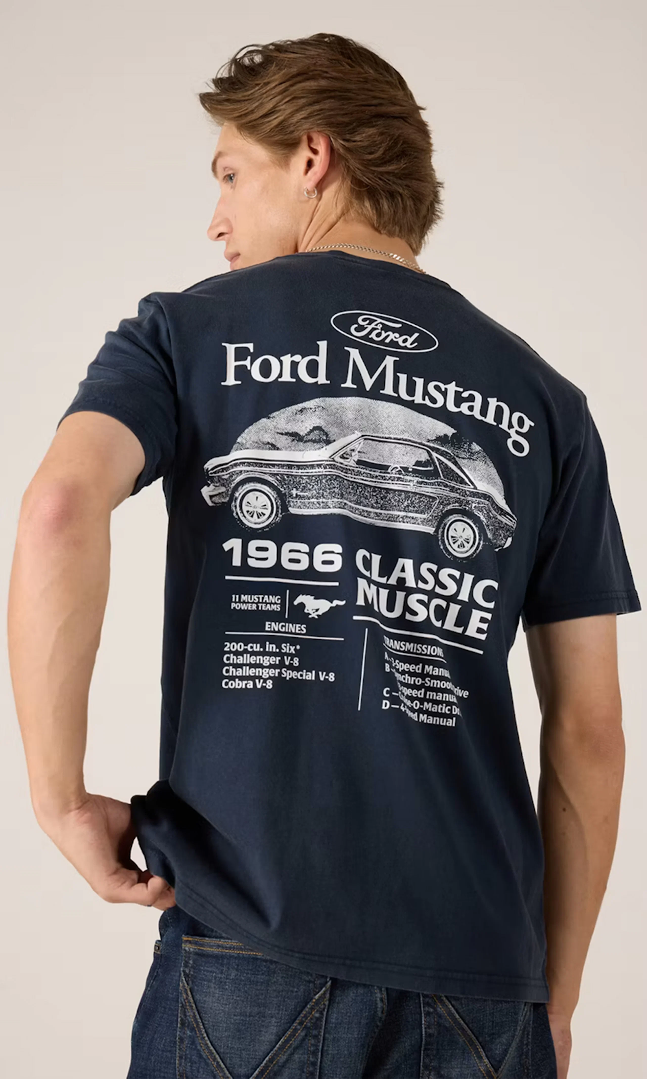 Man bakifrån i mörkblå t-shirt med Ford Mustang 1966 Classic Muscle-tryck i vitt, kombinerad med mörkblå jeans.