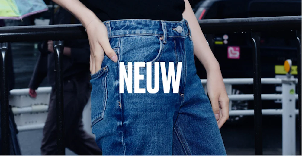 Person i blå jeans med händerna i fickorna, med texten NEUW i vitt över bilden.