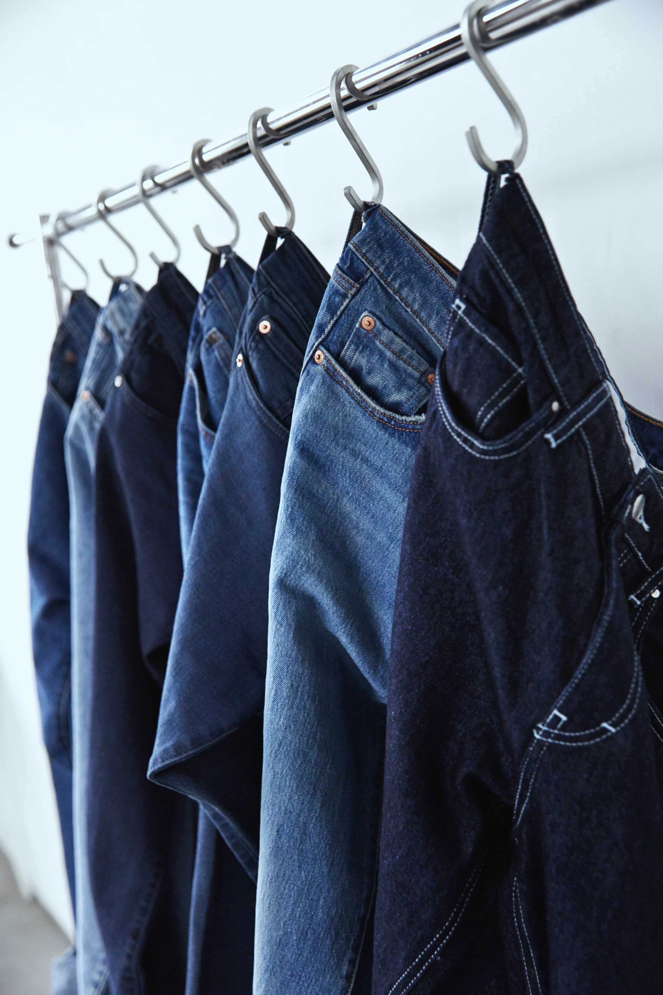 Jeans hanging on a rack in different denim shades
