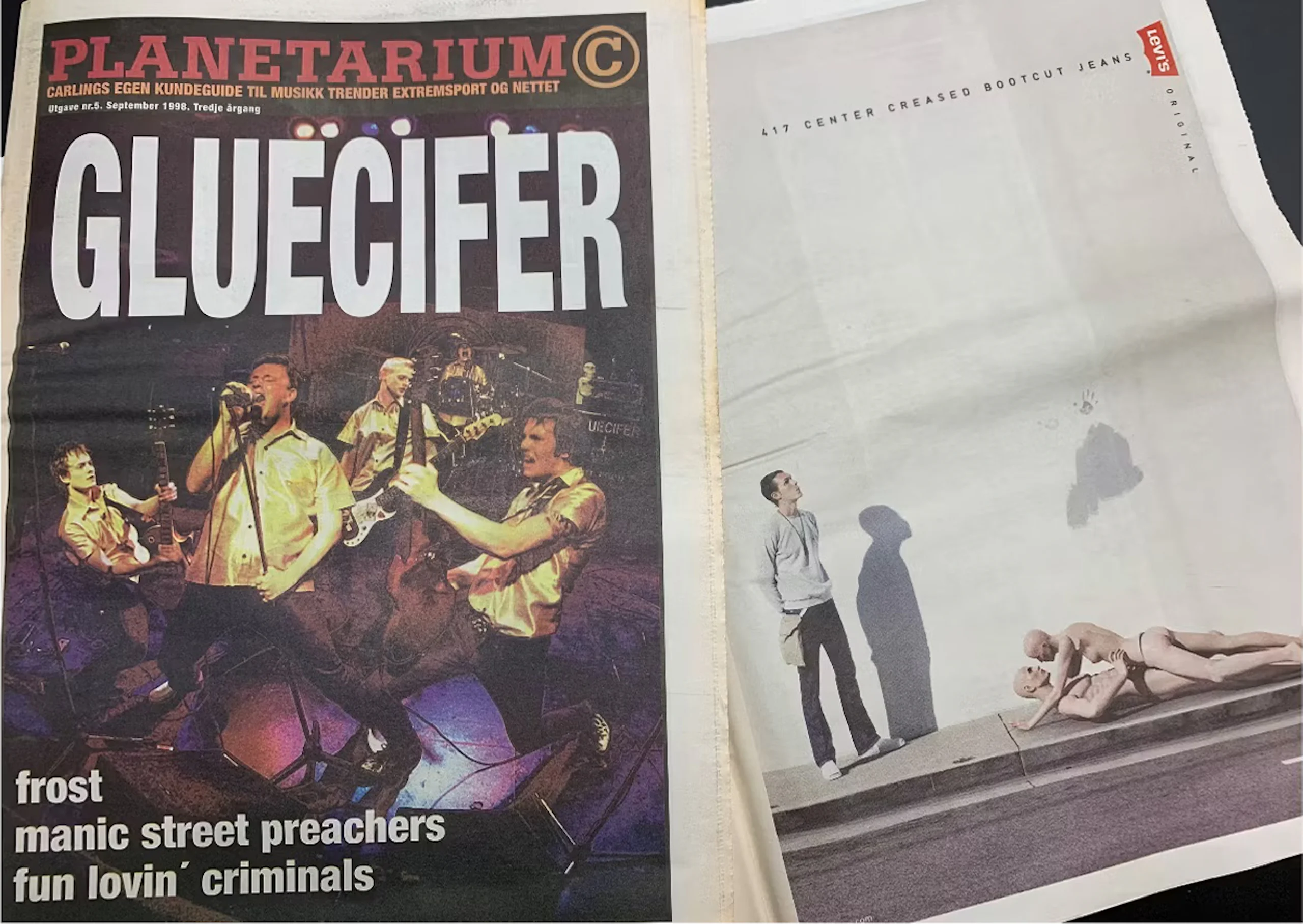 Tidningsuppslag som visar ett liveband på vänster sida under den stora rubriken "GLUECIFER" och en minimalistisk Levi's-annons till höger med en stående man och två skyltdockor på trottoaren.